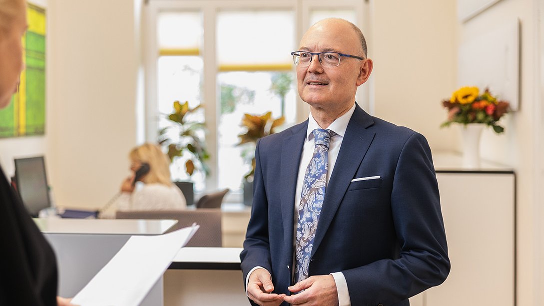 Notar Ralf Korte bespricht am Empfang ein Schriftstück mit einer Mitarbeiterin