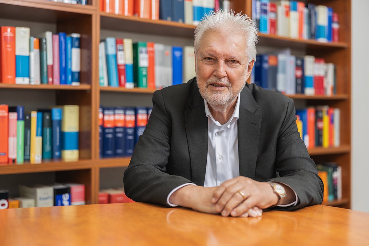 Notar a. D. Peter Schönefuß vor einem Bücherregal mit Gesetzessammlungen