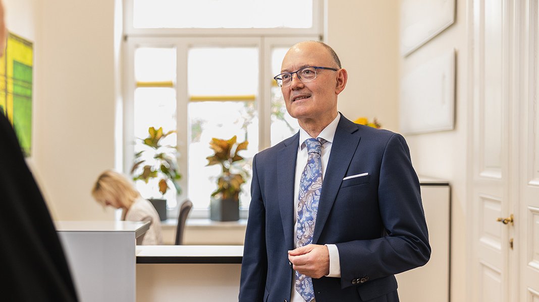 Notar Ralf Korte im Gespräch mit einer Mitarbeiterin im Empfangsbereich des Notariats